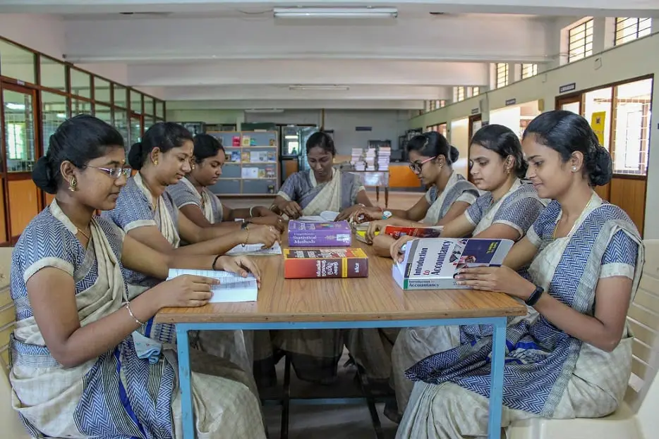 Student-teachers work together around tables.