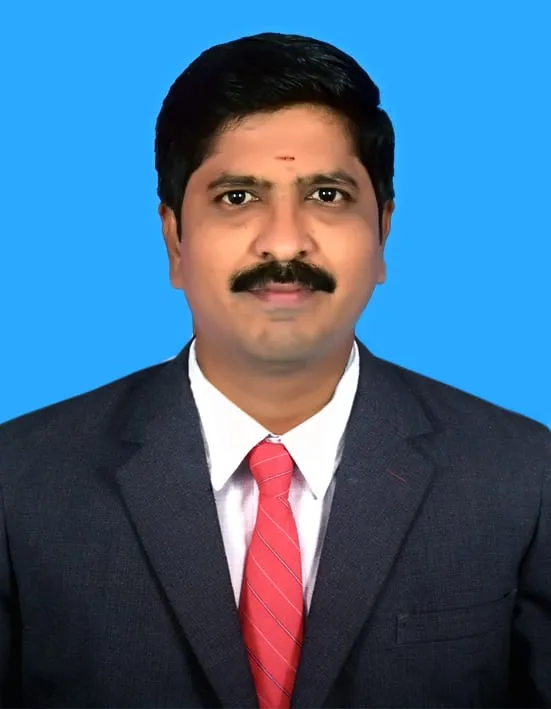 Dr. S. Murugan in a dark suit and red tie.