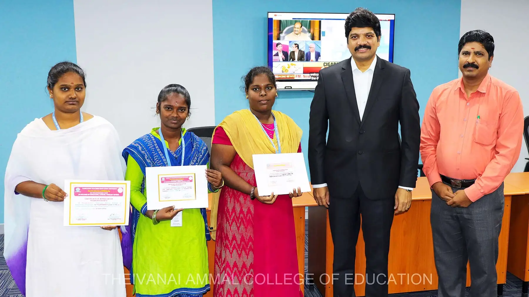 Three students hold certificates beside the Chairman and the Principal.