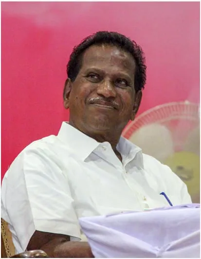 E. Swamikkannu, smiling, in a white shirt.